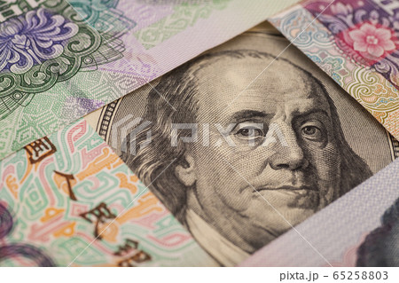 Hundred dollar bill surrounded by Chinese Yuan 65258803