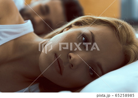 Calm woman awaken in bed near boyfriend 65258985