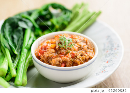Northern Thai food (Nam Prik Ong), spicy chili minced pork with tomatoes eating with vegetables, Thai chili paste	 65260382