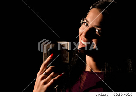 Portrait of young woman recording a song in a professional studio Portrait of young woman recording a song in a professional studio 65267010
