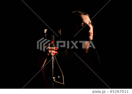 Portrait of young woman recording a song in a professional studio Portrait of young woman recording a song in a professional studio 65267011