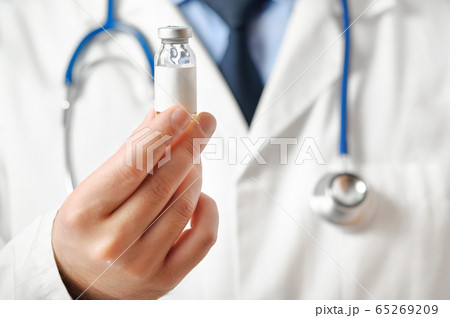 Doctor in a white coat offers vaccine in his hands.Pharmacy. Medication. Selective focus. 65269209