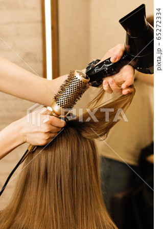Hairdresser styling little girl client 65272334