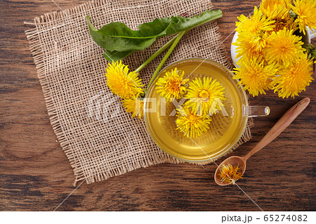 Cup ph healthy dandelion tea on vintage wooden background. Fresh herbs. Cup ph healthy dandelion tea on vintage wooden background. Fresh herbs. 65274082