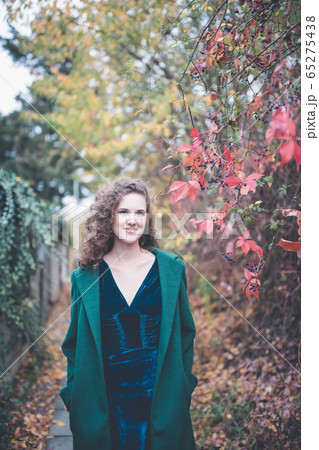 Beautiful girl in a green coat in an autumn park 65275438