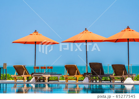 Umbrella and chair around outdoor swimming pool neary sea in hotel resort Umbrella and chair around outdoor swimming pool neary sea in hotel resort 65277545