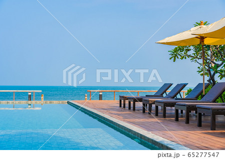 Beautiful empty chair umbrella around outdoor swimming pool in hotel resort for travel 65277547