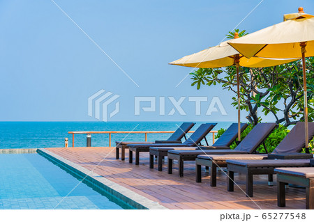 Beautiful empty chair umbrella around outdoor swimming pool in hotel resort for travel Beautiful empty chair umbrella around outdoor swimming pool in hotel resort for travel 65277548