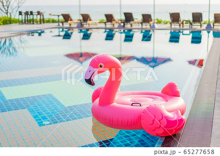 Flamingo float around swimming pool in hotel resort with umbrella and chair in hotel resort Flamingo float around swimming pool in hotel resort with umbrella and chair in hotel resort 65277658