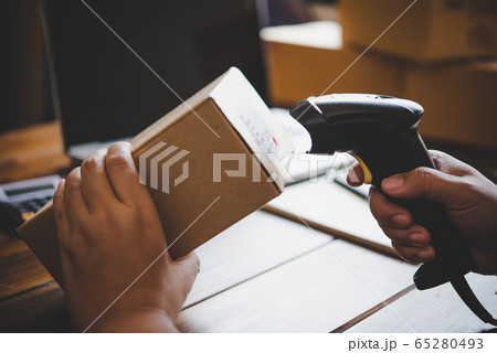 Delivery staff scanning cardboard box with barcode Delivery staff scanning cardboard box with barcode 65280493
