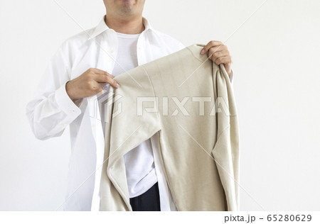 スーツから私服へ着替えている男性 65280629