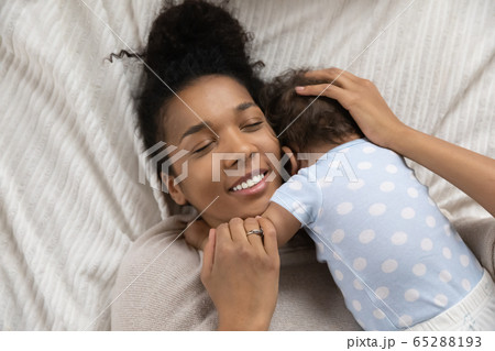 Top view of biracial mom hugging little baby Top view of biracial mom hugging little baby 65288193