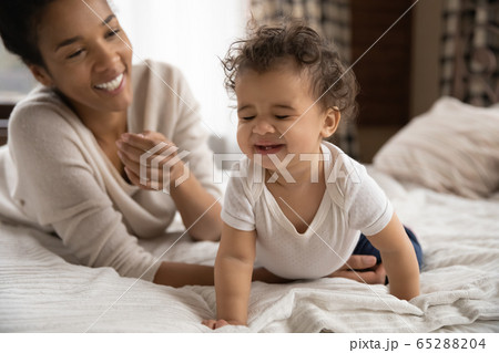 African American mom play with happy toddler in bedroom African American mom play with happy toddler in bedroom 65288204