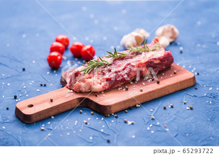 Raw beef fillet steaks with herbs and spices on wooden background 65293722
