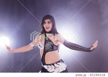 Young woman dancing in Tribal Fusion style. Belly dance on the stage. 65294316