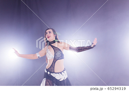 Young woman dancing in Tribal Fusion style. Belly dance on the stage. 65294319