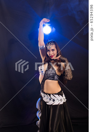 Girl dancing belly dance, fusion or tribal. A woman in a beautiful costume demonstrates charming and gentle movements in the dance. 65294396