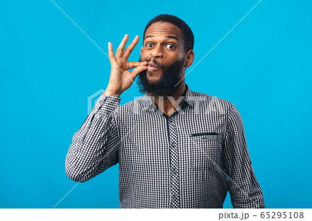 Funny african man making zipping lips gesture with hand 65295108