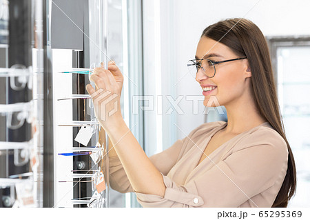 Portrait of beautiful young girl choosing spectacles Portrait of beautiful young girl choosing spectacles 65295369