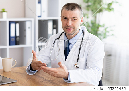 Portrait of mature doctor talking at camera 65295426