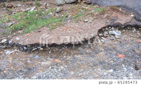 Water erosion of the road. Broken asphalt Water erosion of the road. Broken asphalt 65295473