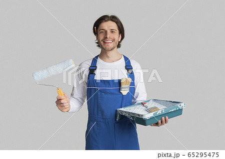 Renovation Services. Smiling Painter In Uniform With Painting Tools In Hands 65295475