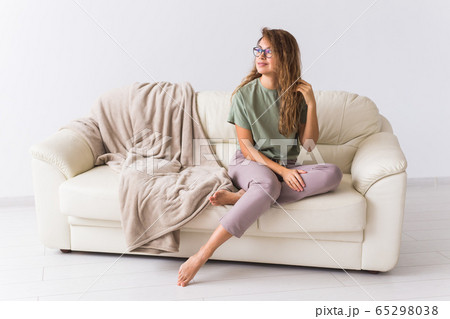 Coronavirus, Covid-19, Quarantine, isolation, coronavirus pandemic world. Stay at home. Pensive woman spending time sitting on sofa at home. 65298038
