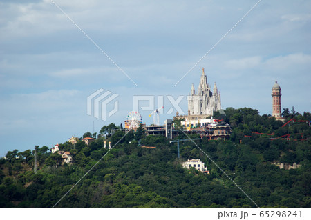 BARCELONA, SPAIN - AUG 30th, 2017: Panoramic view of the city Tibidabo Mountain in far distance from the bunkers de carmel on a cloudy day BARCELONA, SPAIN - AUG 30th, 2017: Panoramic view of the city Tibidabo Mountain in far distance from the bunkers de carmel on a cloudy day 65298241