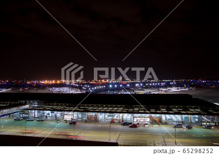 CHICAGO, ILLINOIS, UNITED STATES - MAY 11th, 2018: Outside of Chicago O'Hare International Airport at night with some cars and airplanes at the terminal 65298252