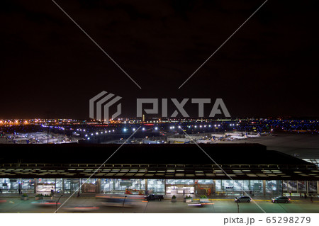 CHICAGO, ILLINOIS, UNITED STATES - MAY 11th, 2018: Outside of Chicago O'Hare International Airport at night with some cars and airplanes at the terminal CHICAGO, ILLINOIS, UNITED STATES - MAY 11th, 2018: Outside of Chicago O'Hare International Airport at night with some cars and airplanes at the terminal 65298279