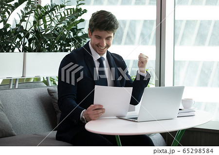 Businessman reading paper financial documentation feels excited Businessman reading paper financial documentation feels excited 65298584