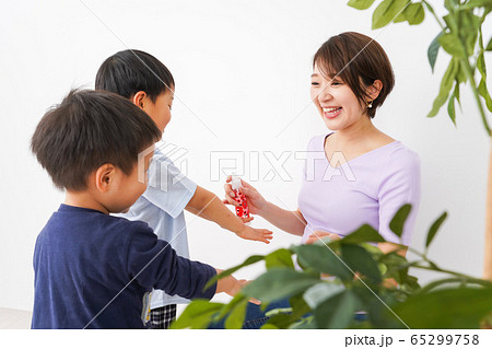 除菌スプレーを子どもにかけるお母さん 65299758