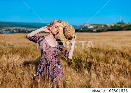 a woman farmer in field of wheat before the harvest a woman farmer in field of wheat before the harvest 65301658