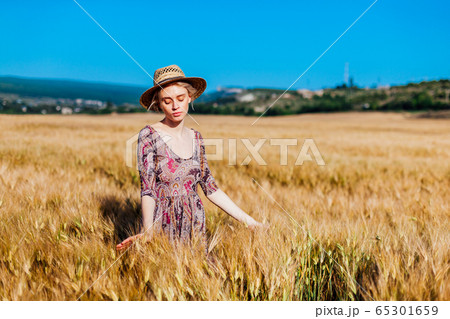 a woman farmer in field of wheat before the harvest a woman farmer in field of wheat before the harvest 65301659