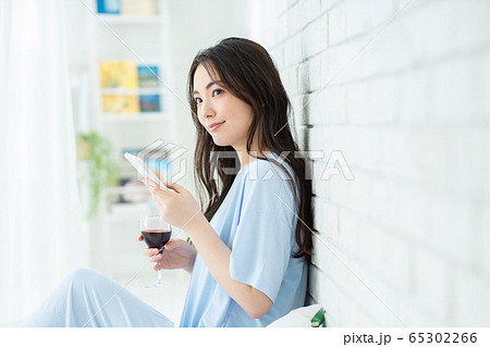 女性　リビング　スマホ　赤ワイン 65302266