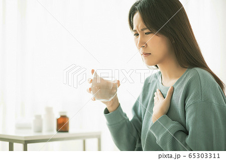 若い　女性　病気　体調不良　具合　悪い　薬　お水　飲む　人物　素材 65303311