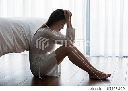 Unhappy woman sitting on floor feels desperate by ruined marriage 65303800