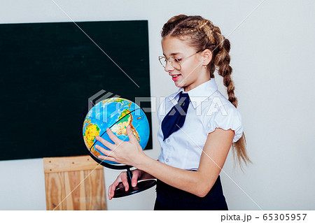 girl with a globe at the Blackboard in a class lesson 65305957