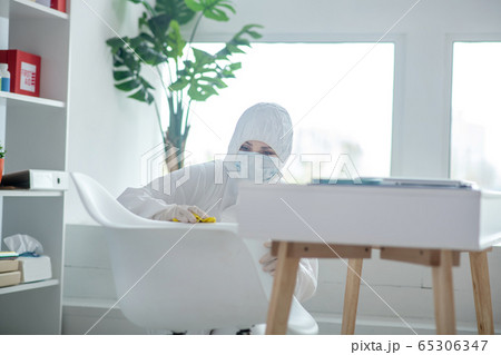 Person in protective workwear disinfecting the room Person in protective workwear disinfecting the room 65306347