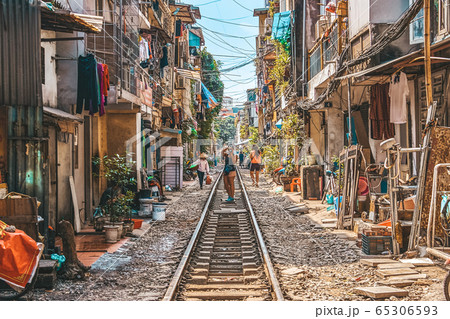 Woman is making a picture of Hanoi city railway Perspective view running along narrow street with houses in Vietnam Woman is making a picture of Hanoi city railway Perspective view running along narrow street with houses in Vietnam 65306593