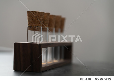 empty walnut holder with glass tubes for spices on concrete surface 65307849