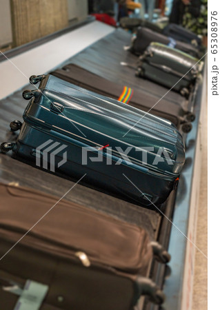 Suitcases on luggage conveyor belt at arrival terminal in airport  65308976