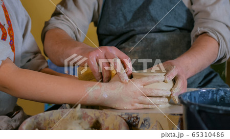Potter showing how to work with ceramic in pottery studio Potter showing how to work with ceramic in pottery studio 65310486
