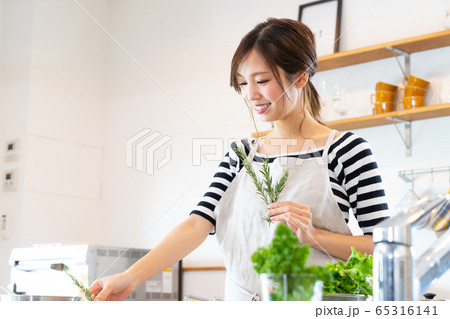 キッチンで料理を作る若い女性 キッチンで料理を作る若い女性 65316141