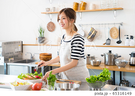 キッチンで料理を作る若い女性 65316149