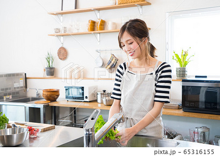 キッチンで料理を作る若い女性 キッチンで料理を作る若い女性 65316155