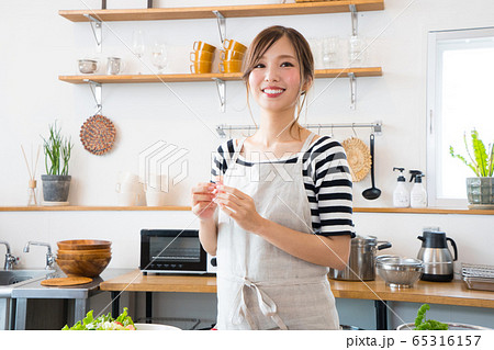 キッチンで料理を作る若い女性 65316157