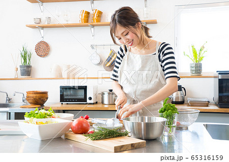 キッチンで料理を作る若い女性 キッチンで料理を作る若い女性 65316159