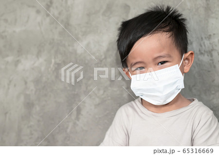 A boy wearing medical face mask for pollution or coronavirus,child itchy eyes and nose, Kid scratching nose while wearing protection mask. A boy wearing medical face mask for pollution or coronavirus,child itchy eyes and nose, Kid scratching nose while wearing protection mask. 65316669