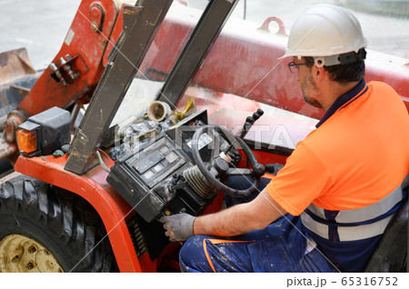 Construction worker starting the excavator machine. Construction worker starting the excavator machine. 65316752